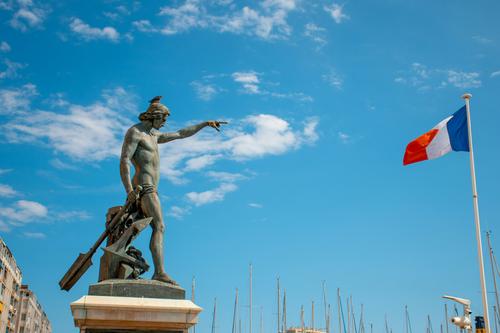 Statue pointing at the Flag of France