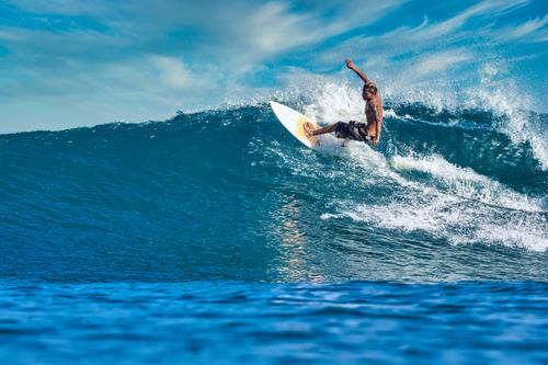 Surfer riding a blue wave