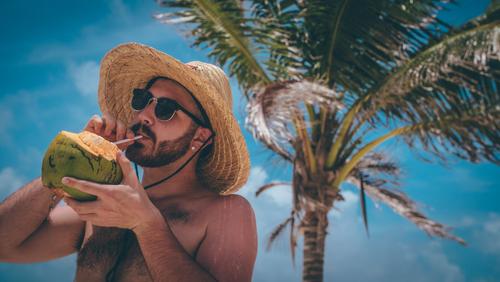 Hombre bebiendo de un coco