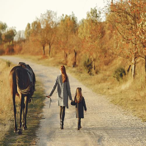 Mother and daughter playing with horse