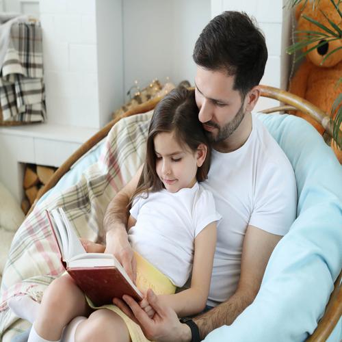 Pai e Filha a Ler um Livro em Casa