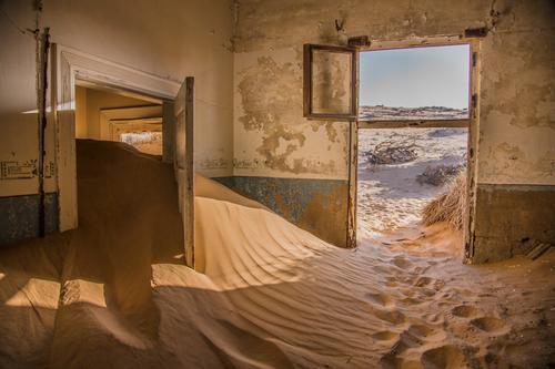 Abandoned building covered in sand