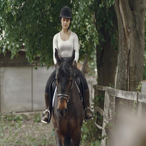 Chica montando un caballo marrón